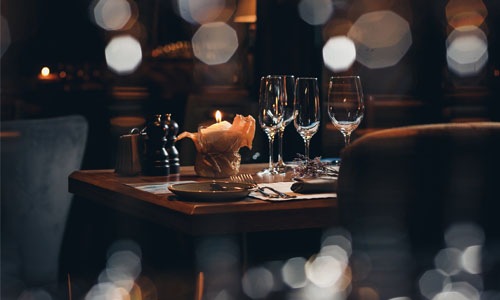wine glasses and a candle in a warm lit restaurant